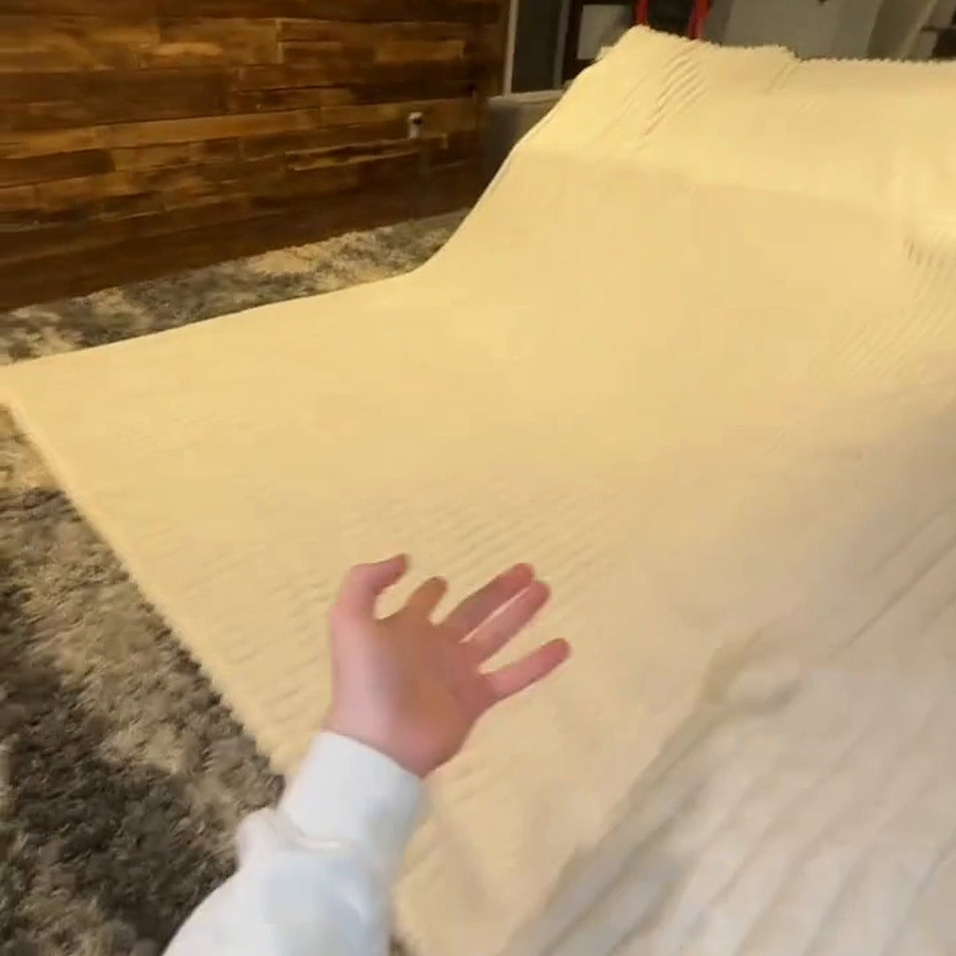 Real footage: a hand reaches across the Cream blanket spread over a whole bed, showing the scale.