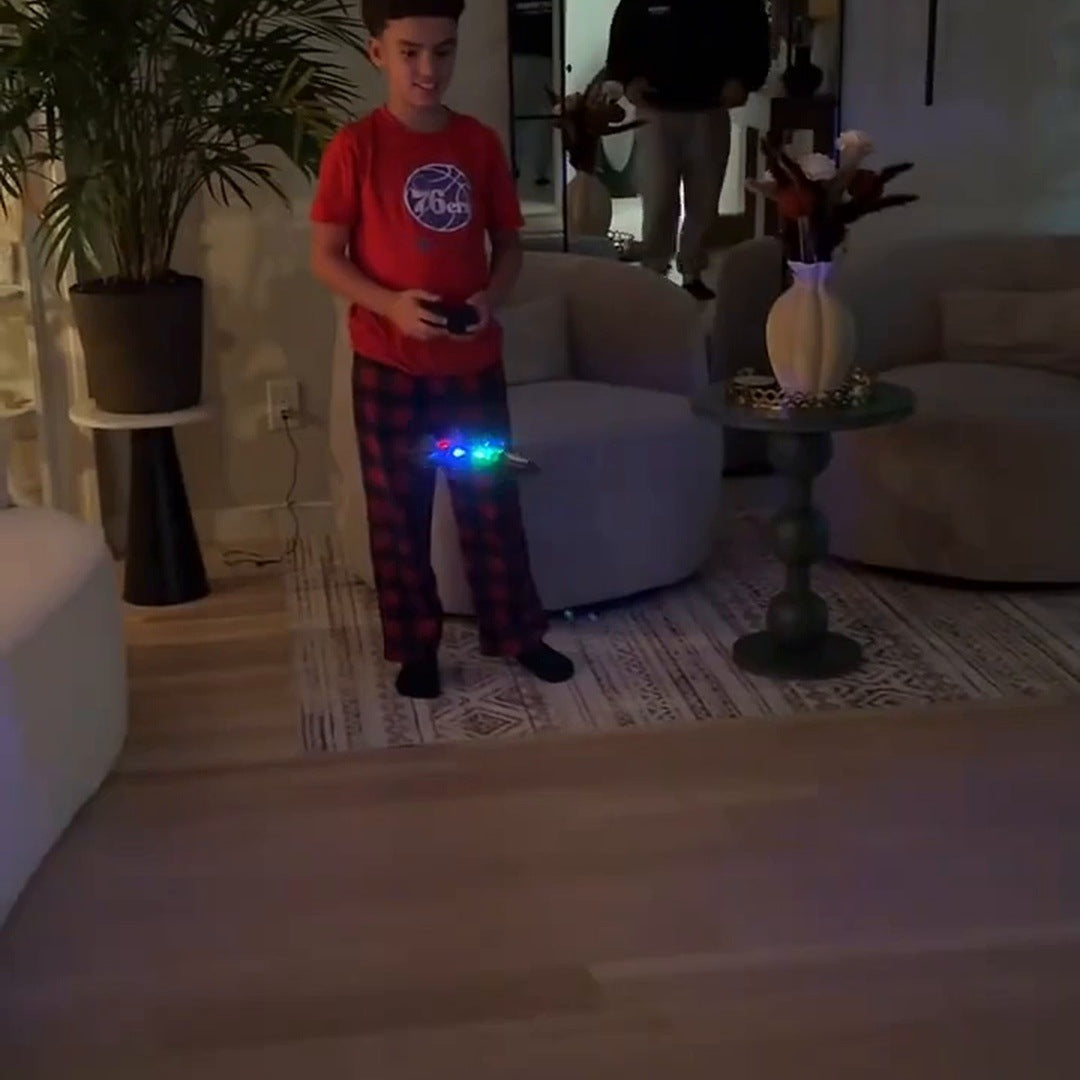 boy in a red shirt flying the glowing jet in a dim living room, his dad behind