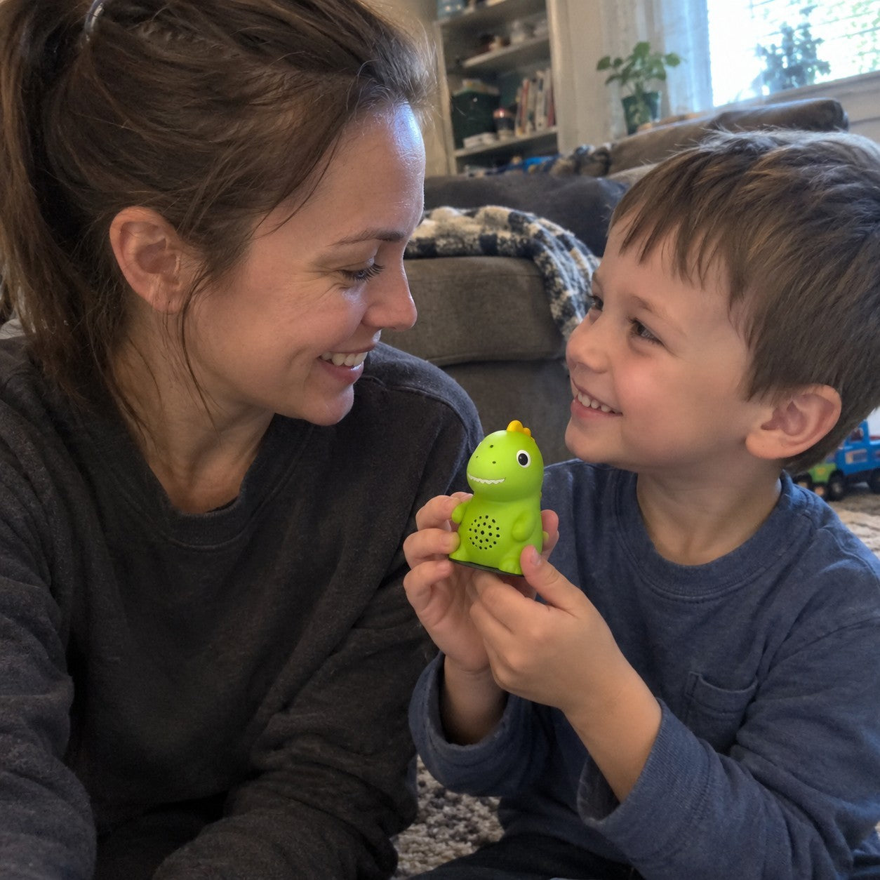 Mom and son on the floor playing with the green dino