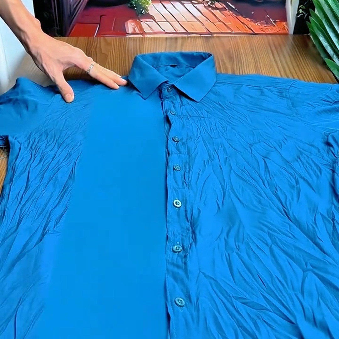 Smooth teal shirt on a wooden table after steaming