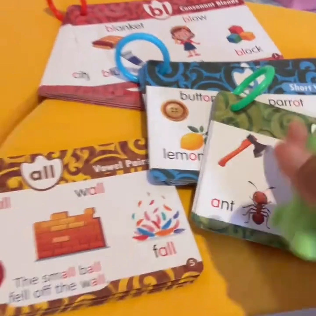 Several illustrated learning cards and colored rings spread over a yellow cushion