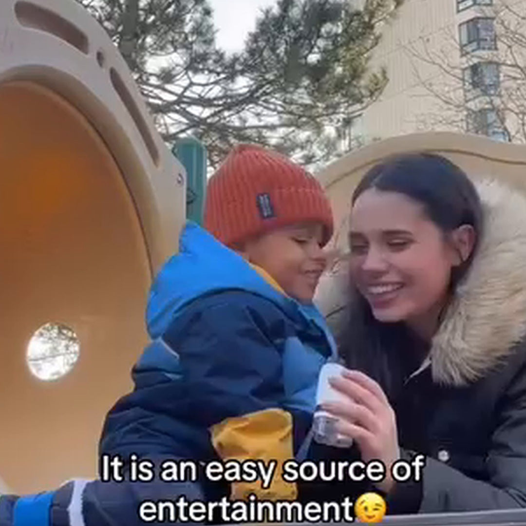 Real creative frame: a mother and red-beanie child smile on a playground