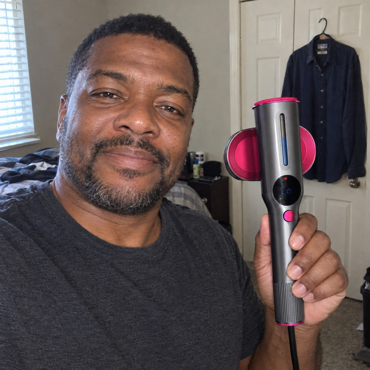 Man holds correct steamer in bedroom selfie