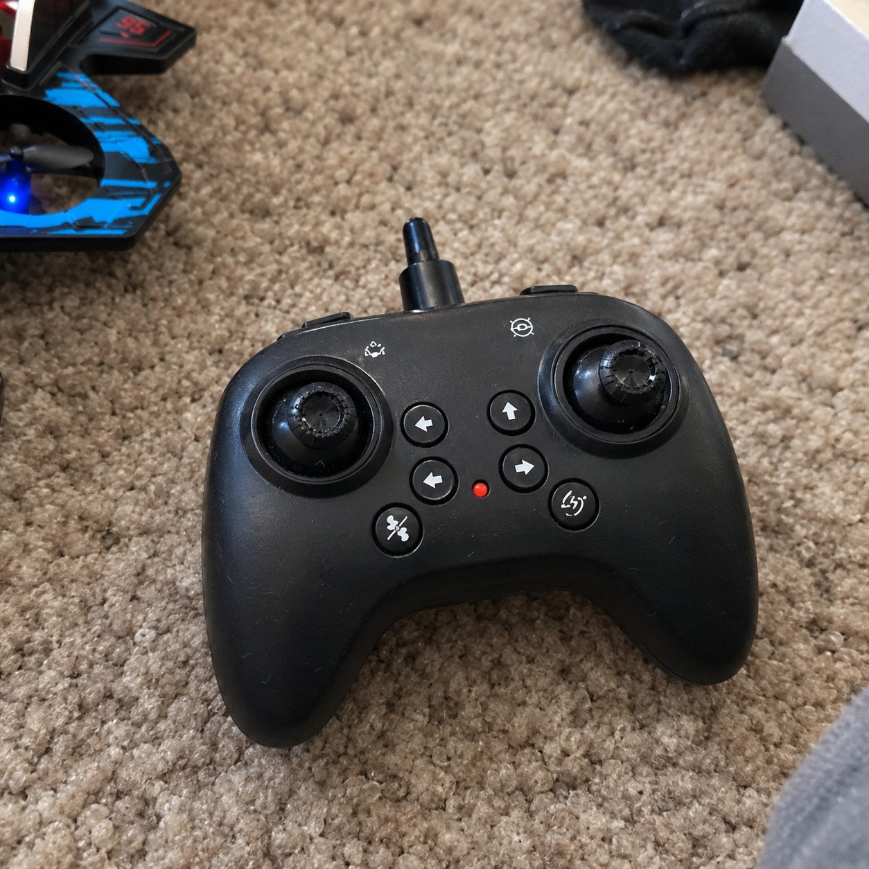 The remote on a carpet with the jet's wing at the edge