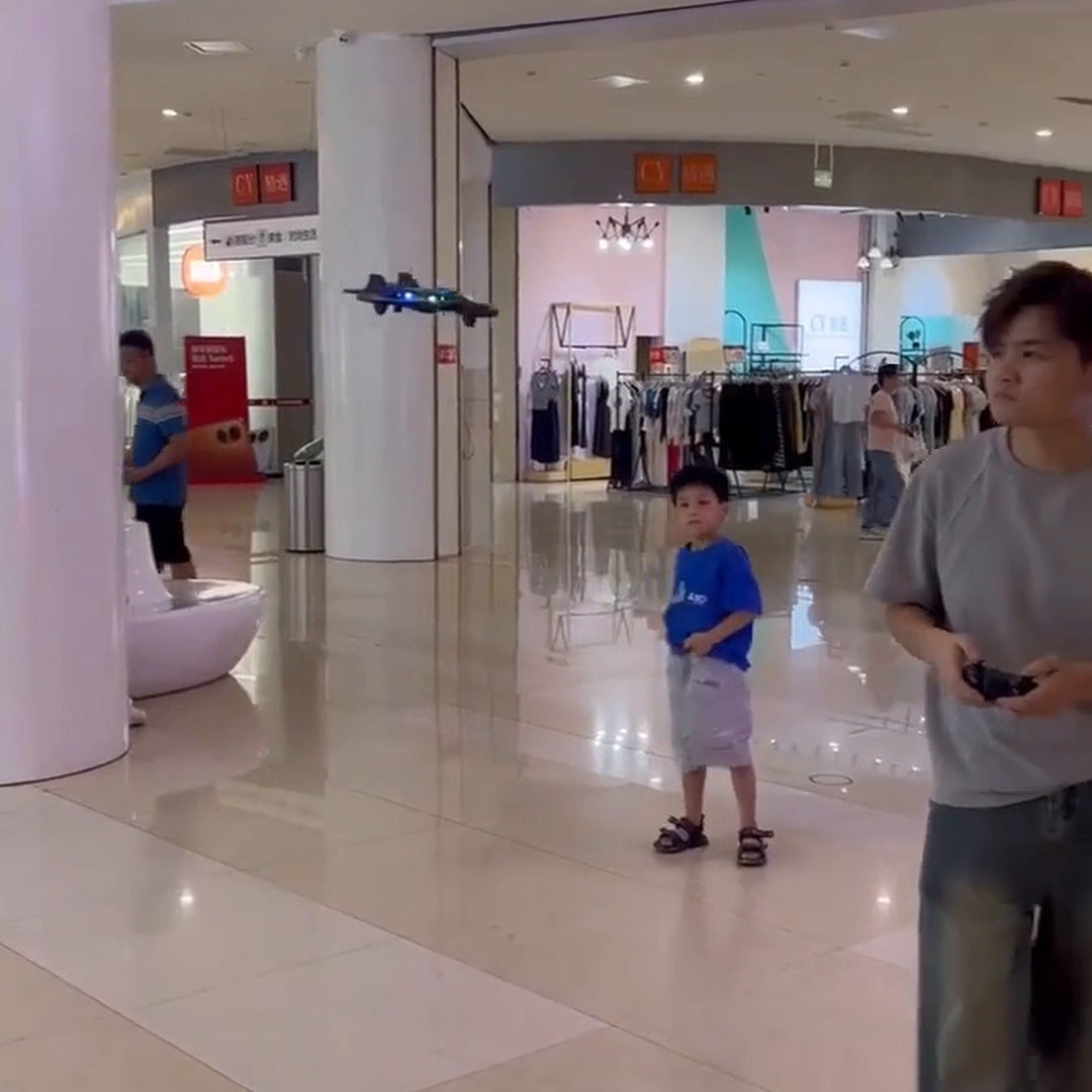 A boy and an adult flying the jet in a mall corridor