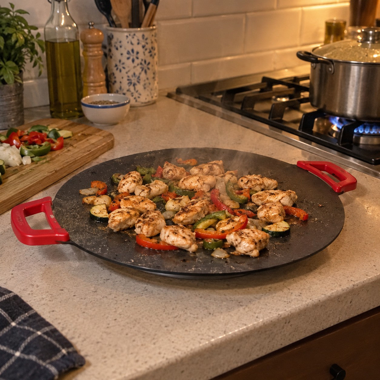 Chicken and peppers cook on the red-handled grill beside a stove with a pot