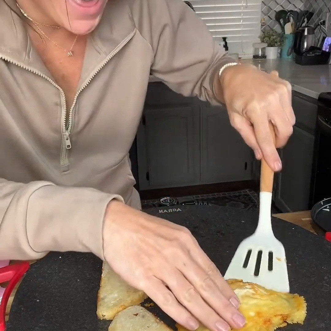 Cook moving an egg toward bread on the grill
